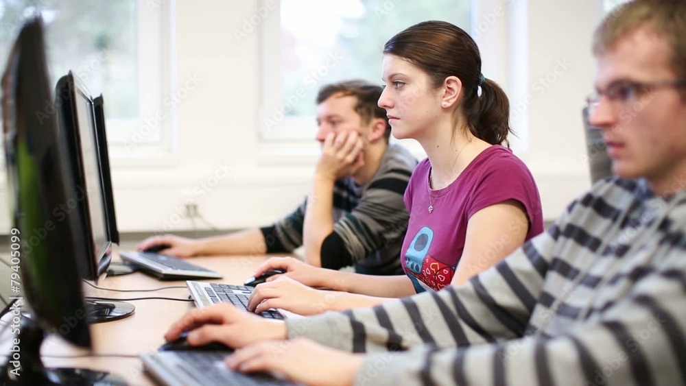 College students sitting in a classroom, using comput College students sitting in a classroom, using comput