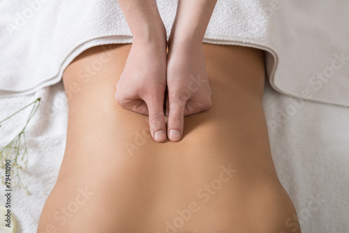 Woman Receiving Back Massage in Spa Center