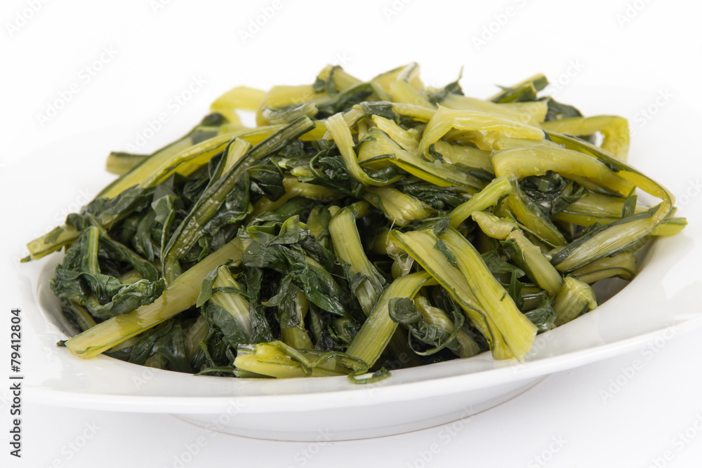 Prepared boiled dandelion greens bowl over white Prepared boiled dandelion greens bowl over white