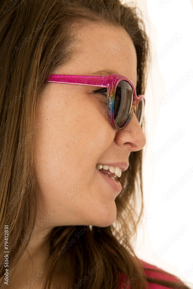 Side portrait of a young woman wearing pink sunglasses Side portrait of a young woman wearing pink sunglasses