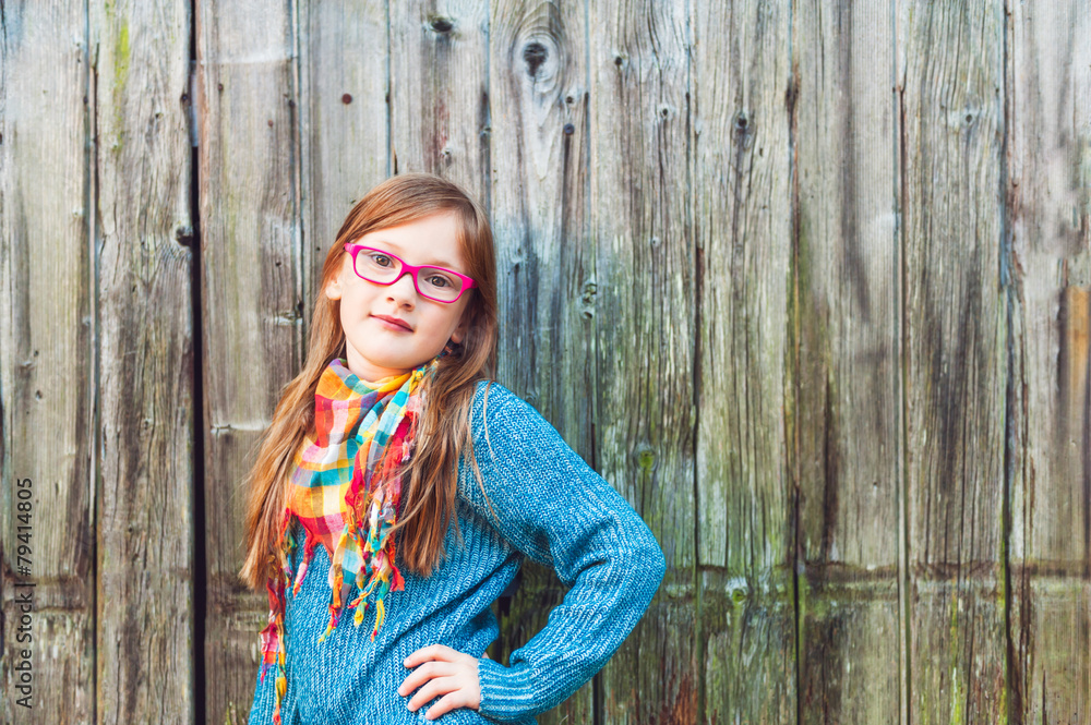 Fototapeta premium Outdoor portrait of a cute little girl in glasses