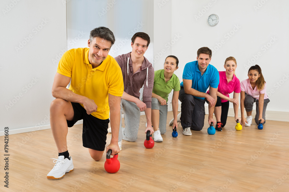 Mature Fitness Instructor With People Exercising