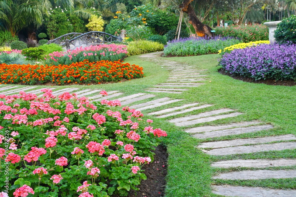Brown chair in a flowers garden with walkway
