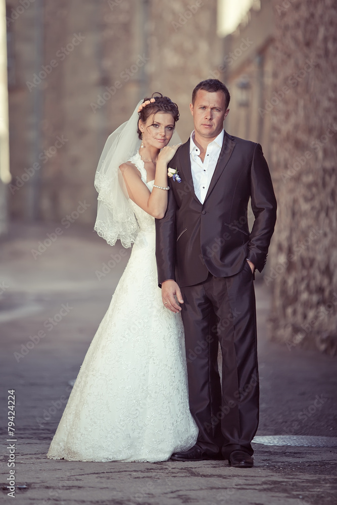 Fototapeta premium Groom and bride are walking in old town