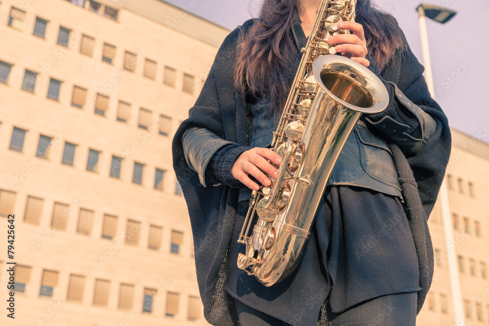 Fototapeta premium Beautiful young woman playing tenor saxophone