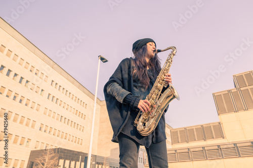 Canvastavla Beautiful young woman playing tenor saxophone