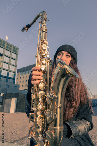 Beautiful young woman with her saxophone