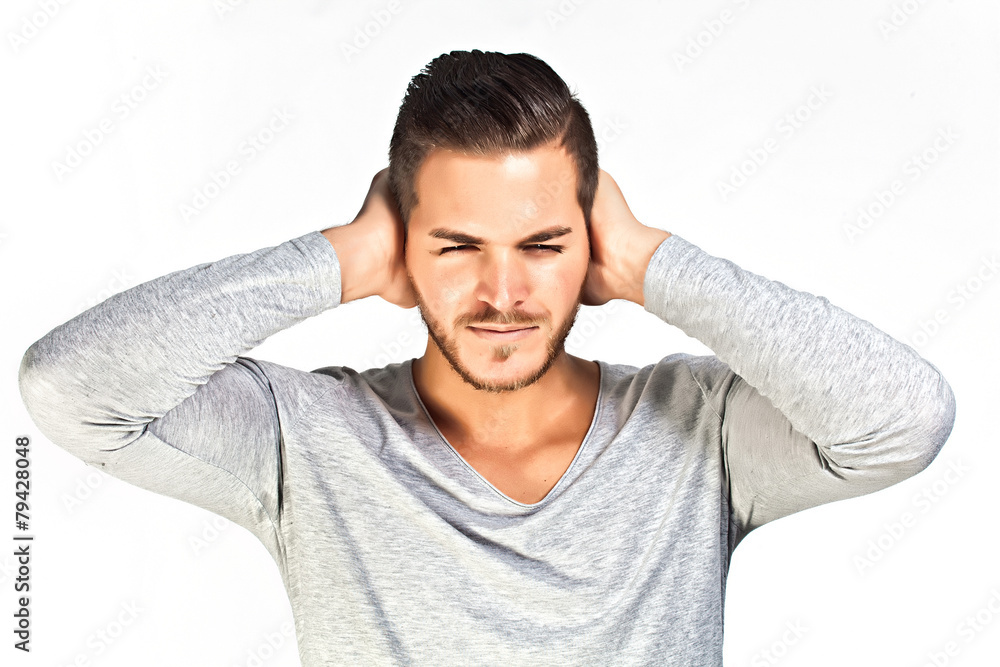 Depressed young man covering ears with hands isolated on white b Depressed young man covering ears with hands isolated on white b