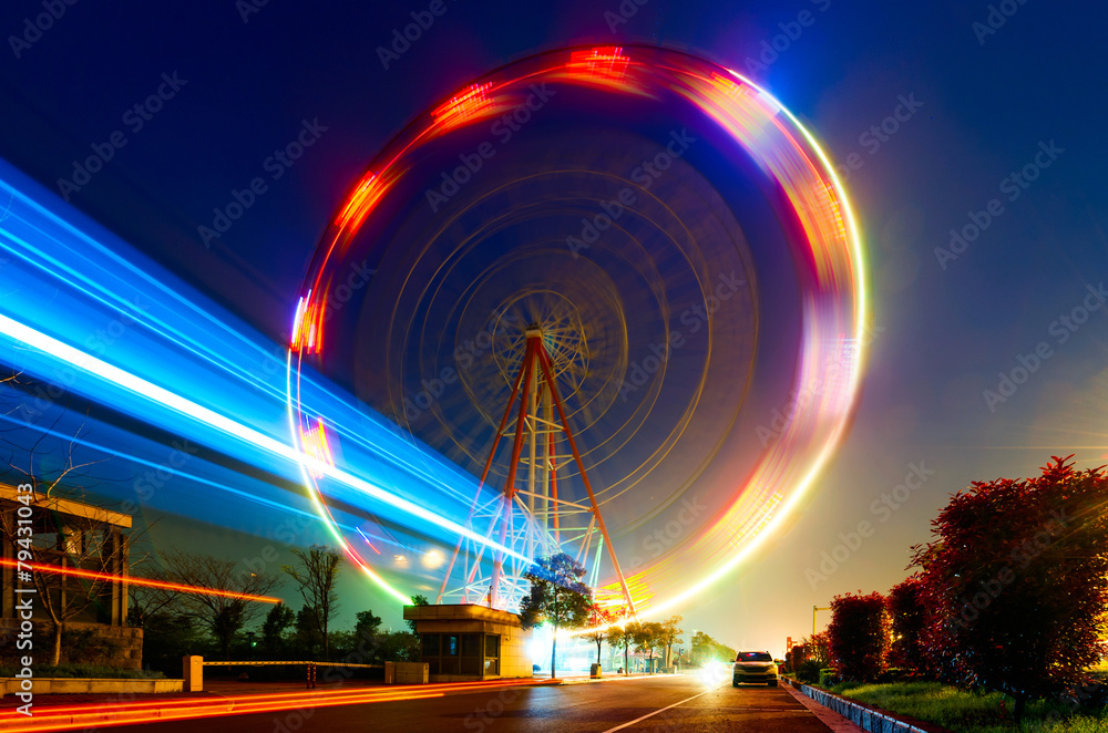 Obraz premium Night, a rotating Ferris wheel.