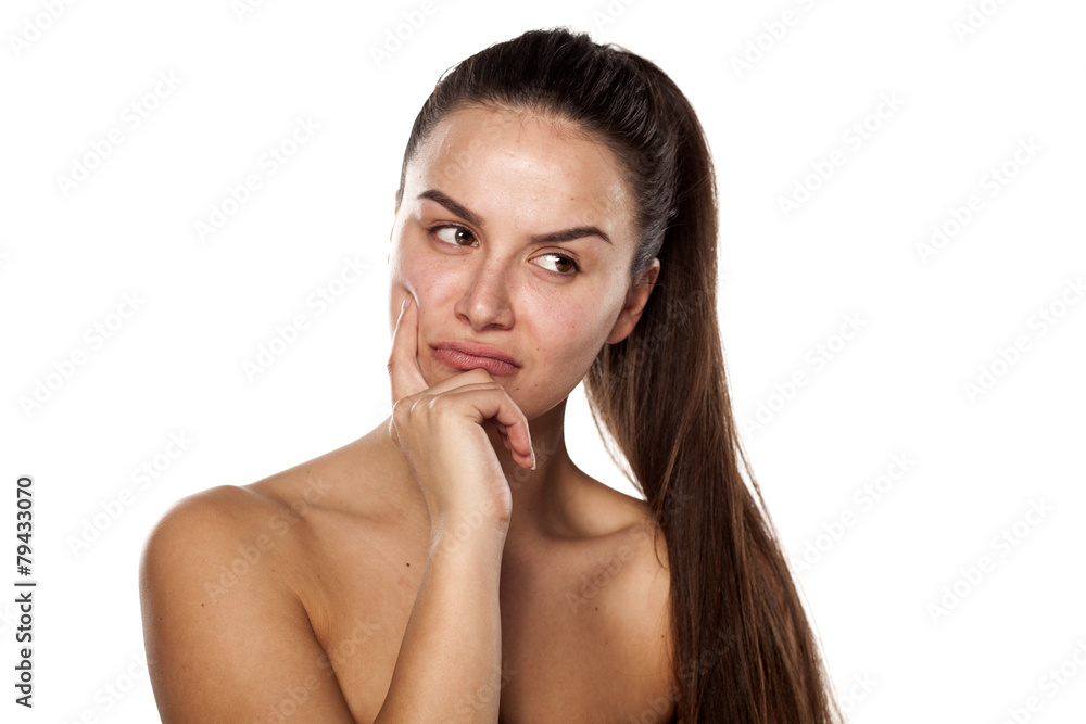 nervous young woman thinking with finger on her face nervous young woman thinking with finger on her face