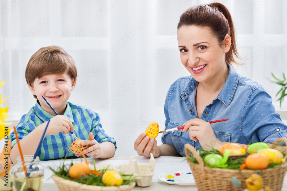 Loving mother and her child painting easter eggs Loving mother and her child painting easter eggs