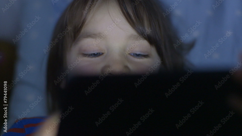 Little girl using touchscreen tablet technology and reading. Little girl using touchscreen tablet technology and reading.