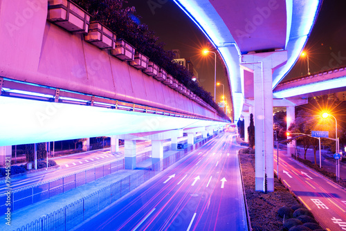 illuminated traffic on elevated expressway in modern city. © zhu difeng