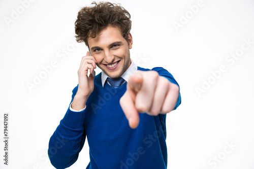 Happy business man talking on the phone and pointing at camera