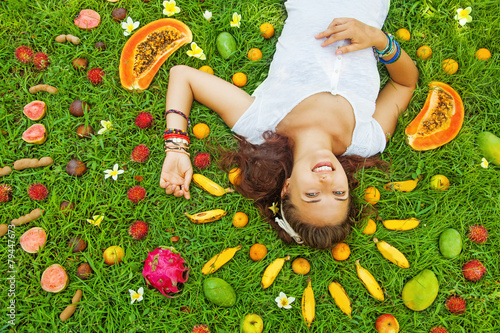 woman lying on a grass with the pattern of colorful fresh exotic photo