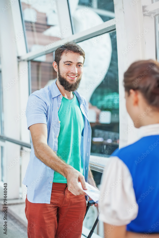 Fototapeta premium Beautiful flight attendant checking documents in airport
