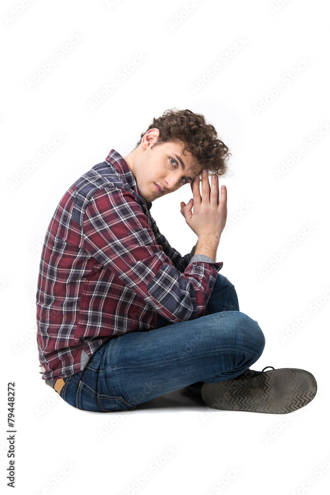 Side view portrait of a young man sitting on the floor Side view portrait of a young man sitting on the floor