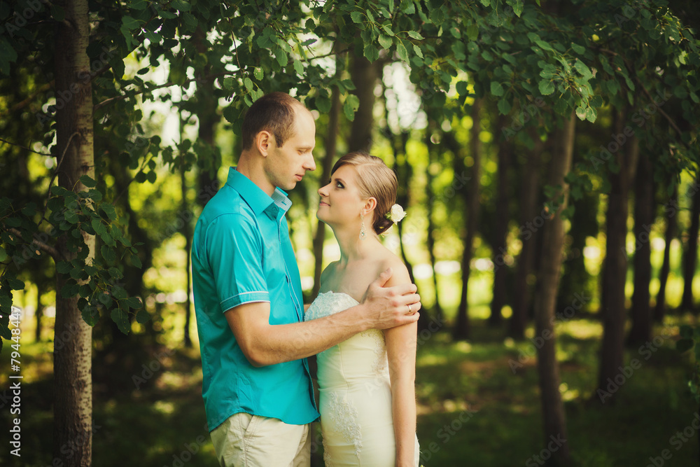 Fototapeta premium Young couple standing in the park on the wedding day.