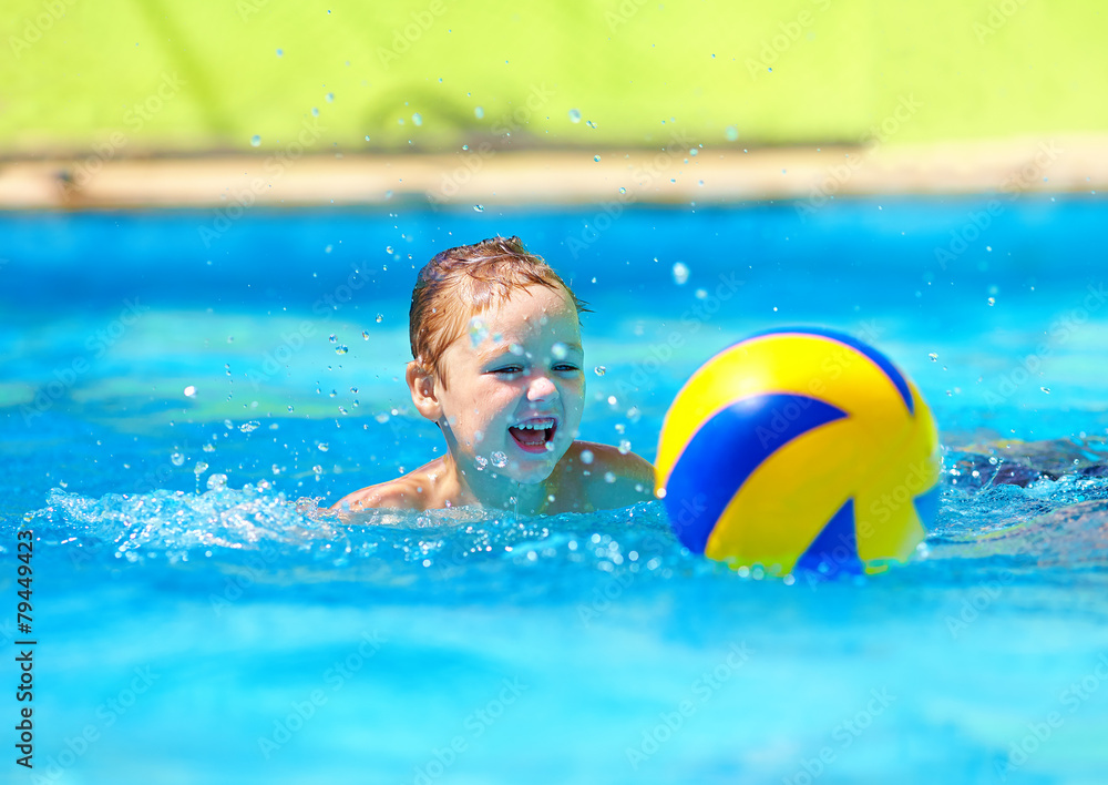 cute kid playing water sport games in pool