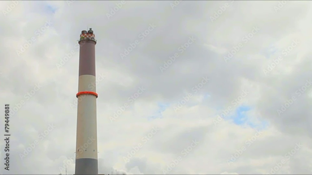 Chimney of power plant   on dark stormy cloudy  sky background