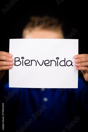 Child holding sign with Spanish word Bienvenida - Welcome
