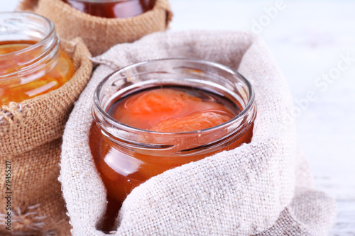 Homemade jars of fruits jam in burlap pouches