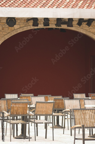 Cafe terrace filled with chairs next to a theatre scene photo