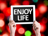 Tablet pc with text Enjoy Life with bokeh background