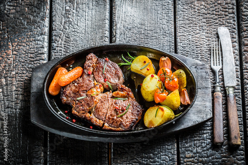 Roasted steak and vegetables with herbs on grill