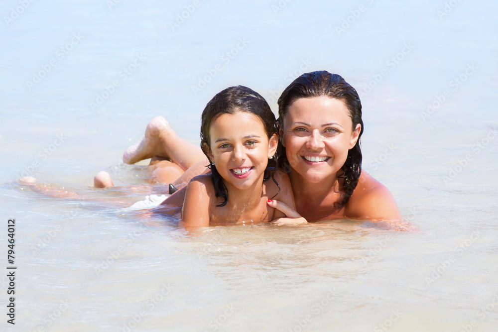 Portrait of cheerful mother and baby girl on sea shore Portrait of cheerful mother and baby girl on sea shore