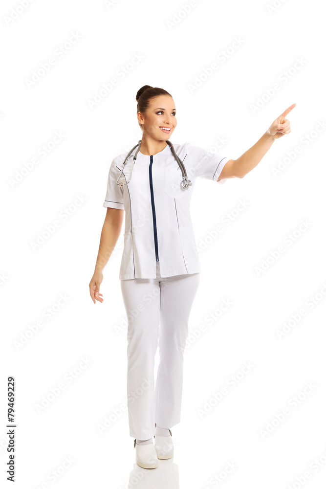 Full length female doctor pointing to the right Full length female doctor pointing to the right