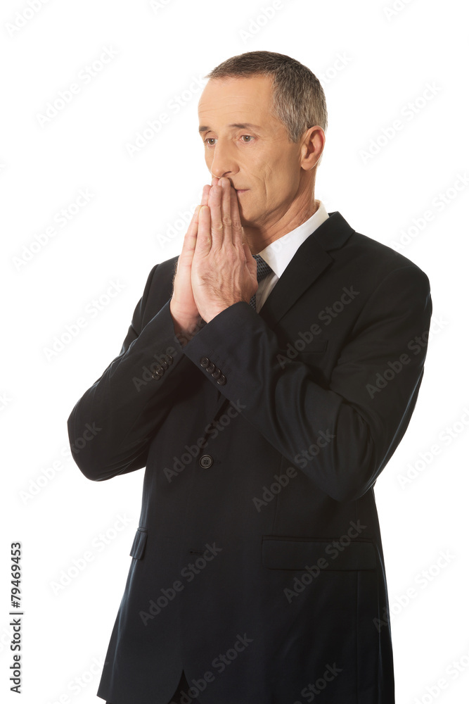 Hopeful businessman with clenched hands Hopeful businessman with clenched hands