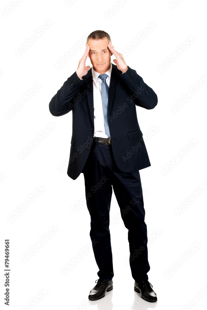 Full length businessman suffering from headache Full length businessman suffering from headache