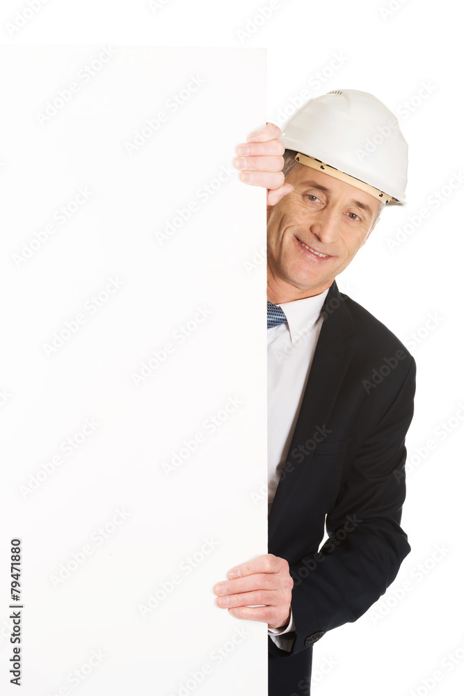 Businessman with hard hat holding empty banner Businessman with hard hat holding empty banner