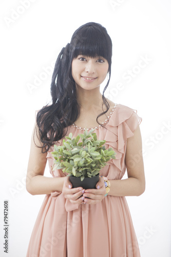 観葉植物を持つ女性