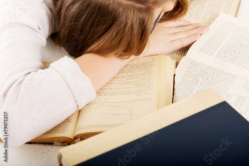 Young worried woman sleeping on books