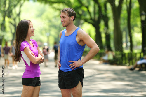 Happy runners couple talking after run in NYC park