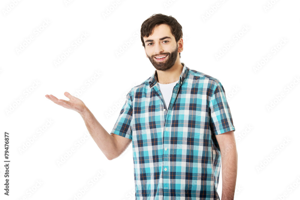 Young man showing something on palm. Young man showing something on palm.