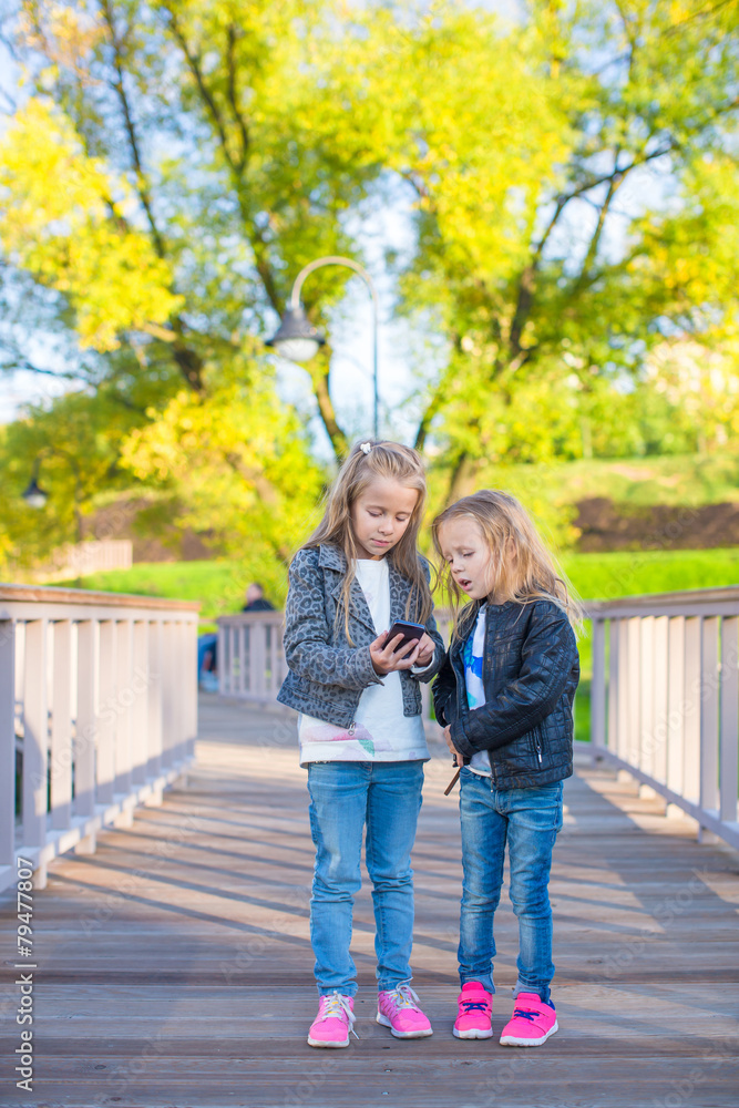 Fototapeta premium Adorable little girls at warm autumn day outdoors