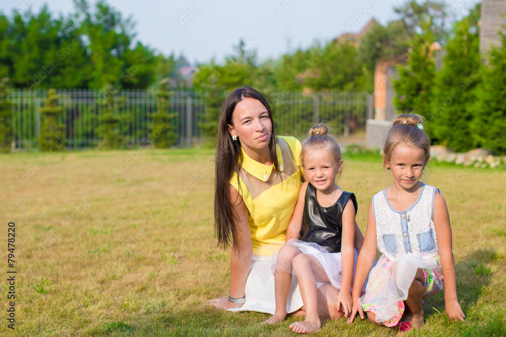 Mother and kids sitting outdoors at beautiful summer park Mother and kids sitting outdoors at beautiful summer park