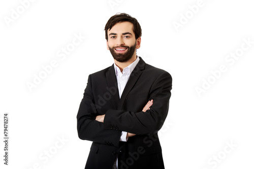 Smiling businessman with folded arms.