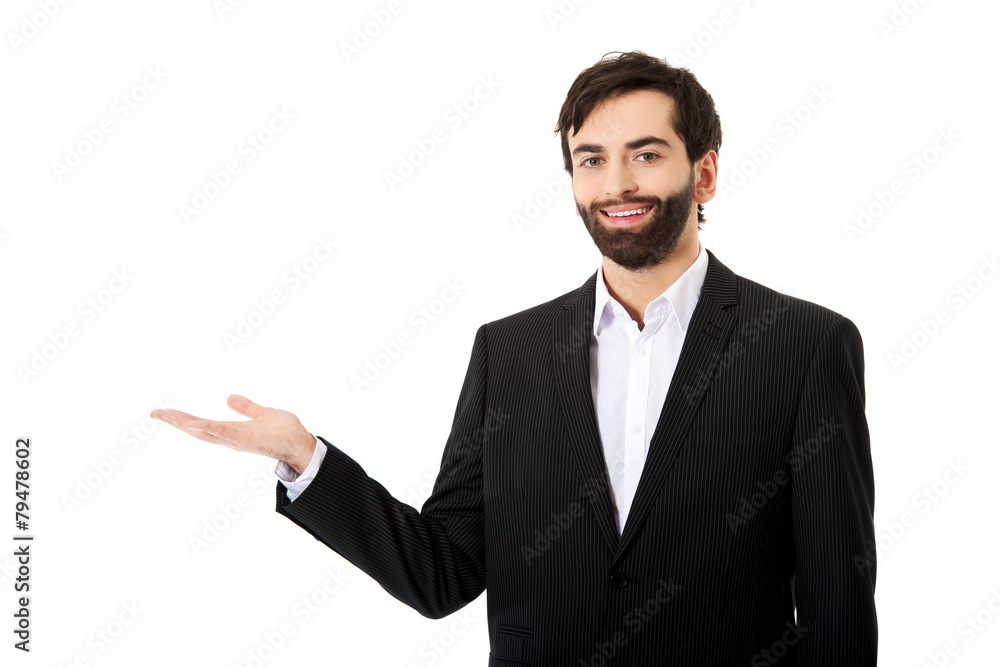 Young businessman showing empty copyspace on hand. Young businessman showing empty copyspace on hand.