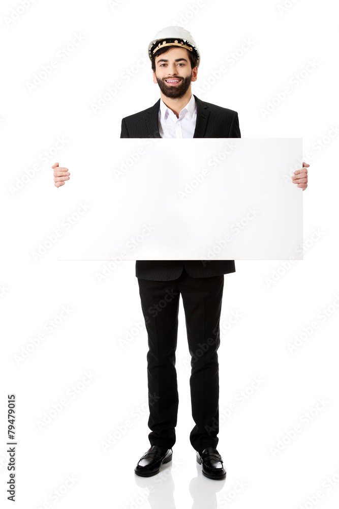 Handsome engineer in helmet holding empty banner. Handsome engineer in helmet holding empty banner.