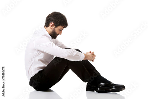 Young businessman sitting on the floor.