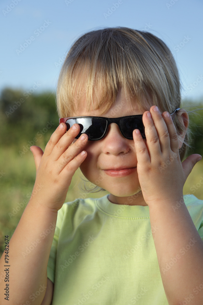 child in sunglasses summer outdoors on a sunny day child in sunglasses summer outdoors on a sunny day
