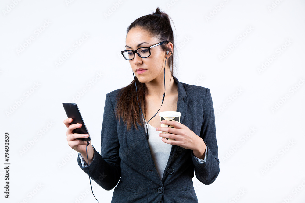 Business woman using her mobile phone and drinking coffee.