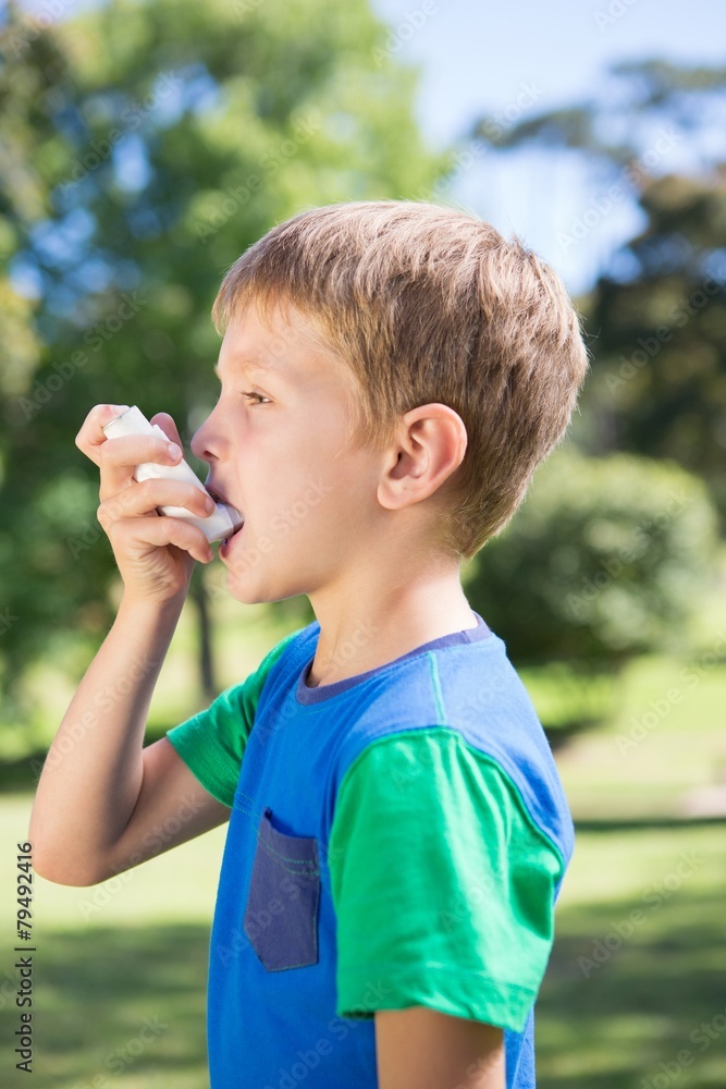 Naklejka premium Little boy using his inhaler