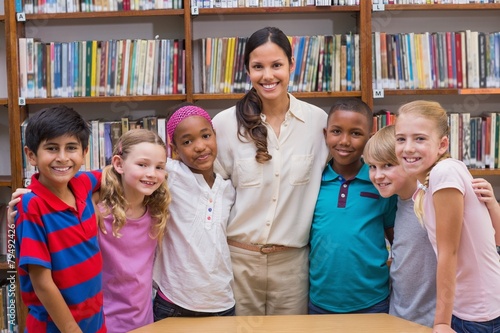 Cute pupils smiling at camera in classroom