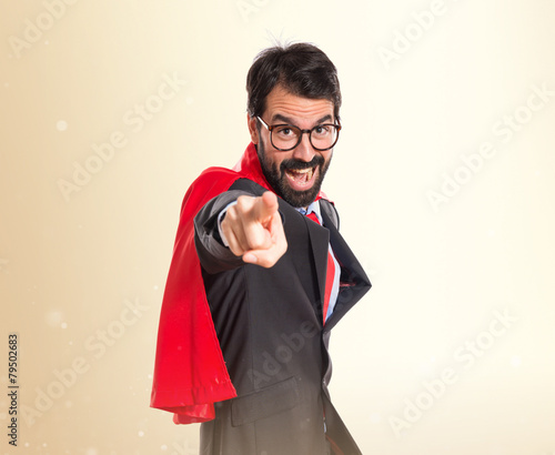 Businessman dressed like superhero pointing to the front