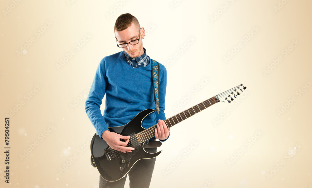 Naklejka premium Young man playing guitar over white background